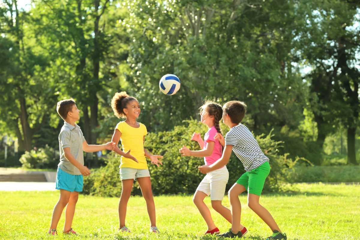 Scatto panoramico mattutino: sentiero all’interno del Parco del Gelso, famiglie che camminano tra alberi e laghetto con Bellaria sullo sfondo