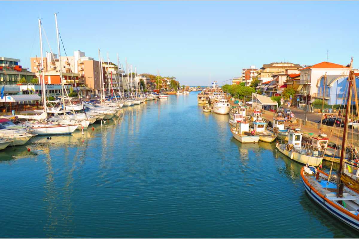 Scorcio della spiaggia di Bellaria con il mare Adriatico sullo sfondo, famiglie che passeggiano sul lungomare, atmosfera estiva e rilassata